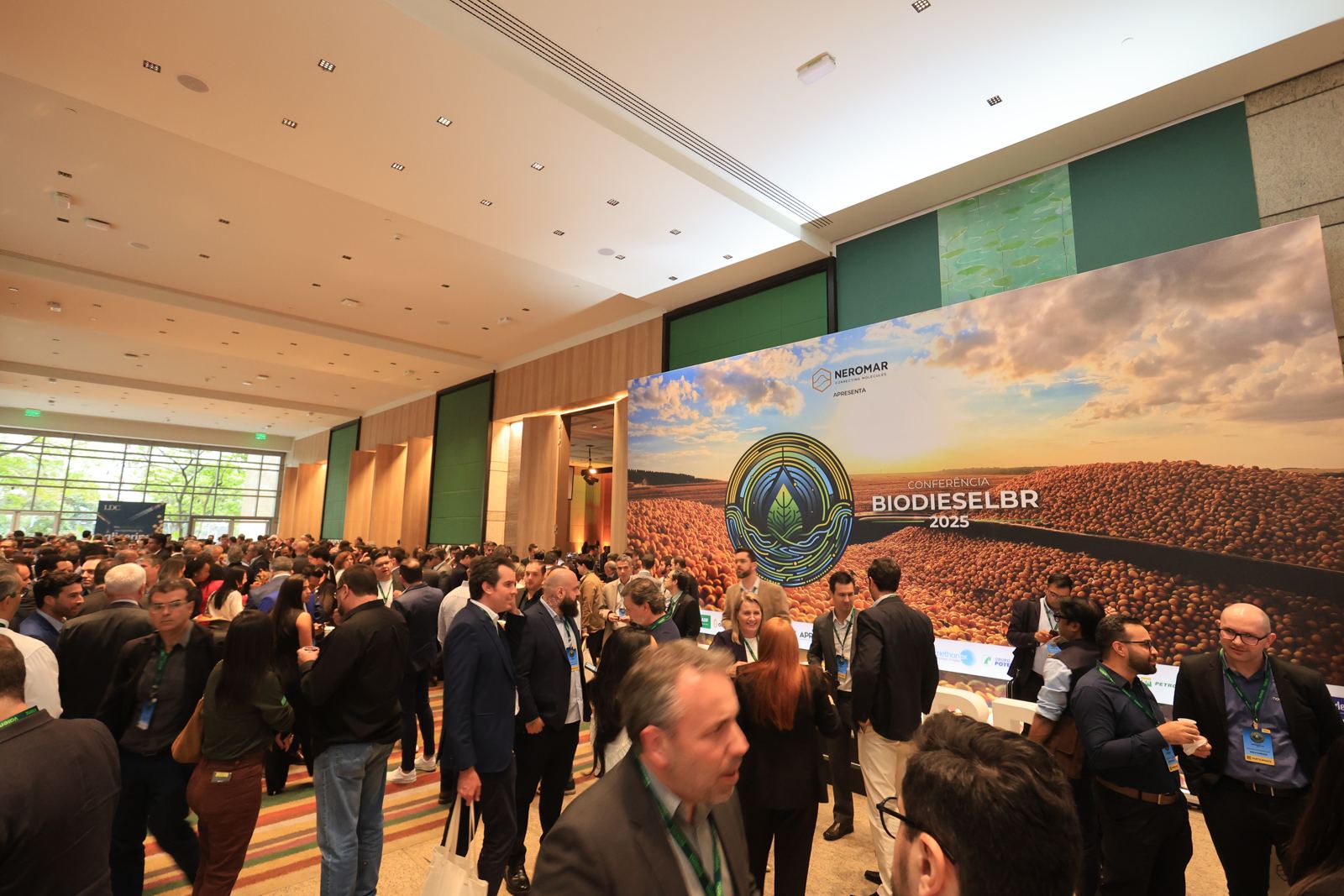 Salão lotado da Conferência BiodieselBR, com o painel do patrocinador apresentante ao fundo