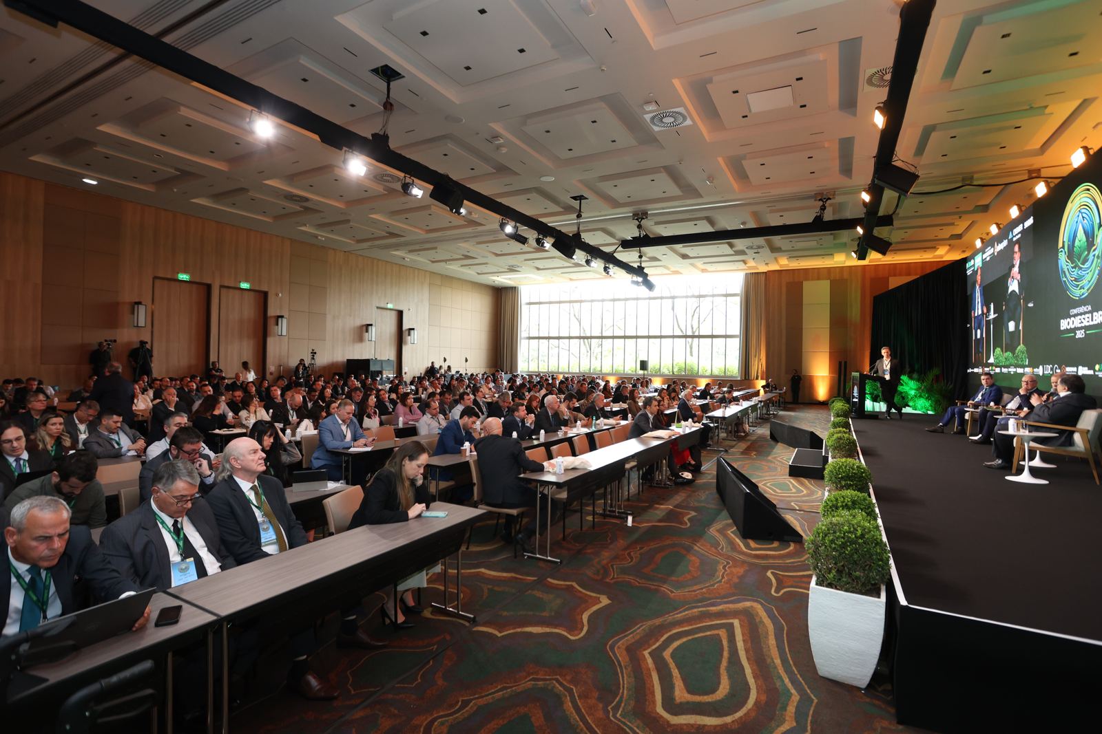 Plenária lotada durante um painel da Conferência BiodieselBR, com o palco e o telão à direita